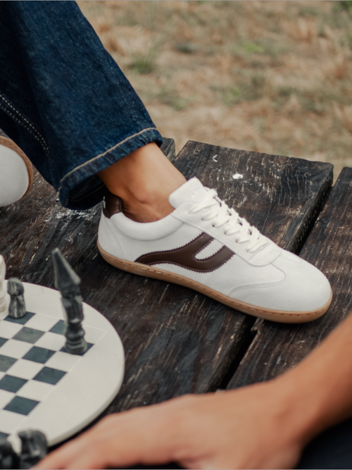 Zapatillas barefoot Atlantic Mist blancas sobre mesa de madera junto a tablero de ajedrez — ARNASA