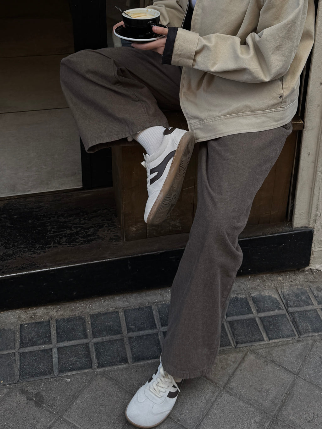 Persona con café en mano llevando zapatillas barefoot Atlantic Mist blanco niebla en ciudad — ARNASA