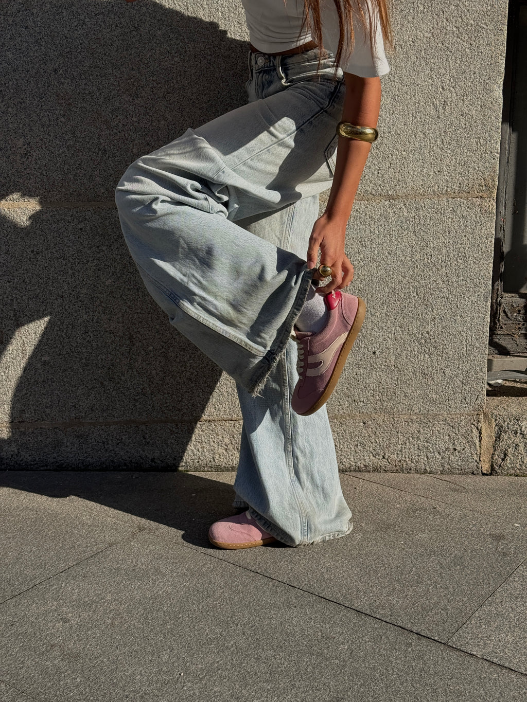 Mujer con vaqueros sujetando zapatilla barefoot Atlantic Bloom rosa empolvado en exterior — ARNASA